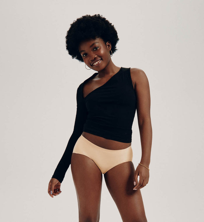 Tracy (she/her) has 37" hips and is wearing a size M | Front view of model wearing the Teen Light Leakproof No-Show Boyshort highlighting the coverage and smooth fit | Warm Sand