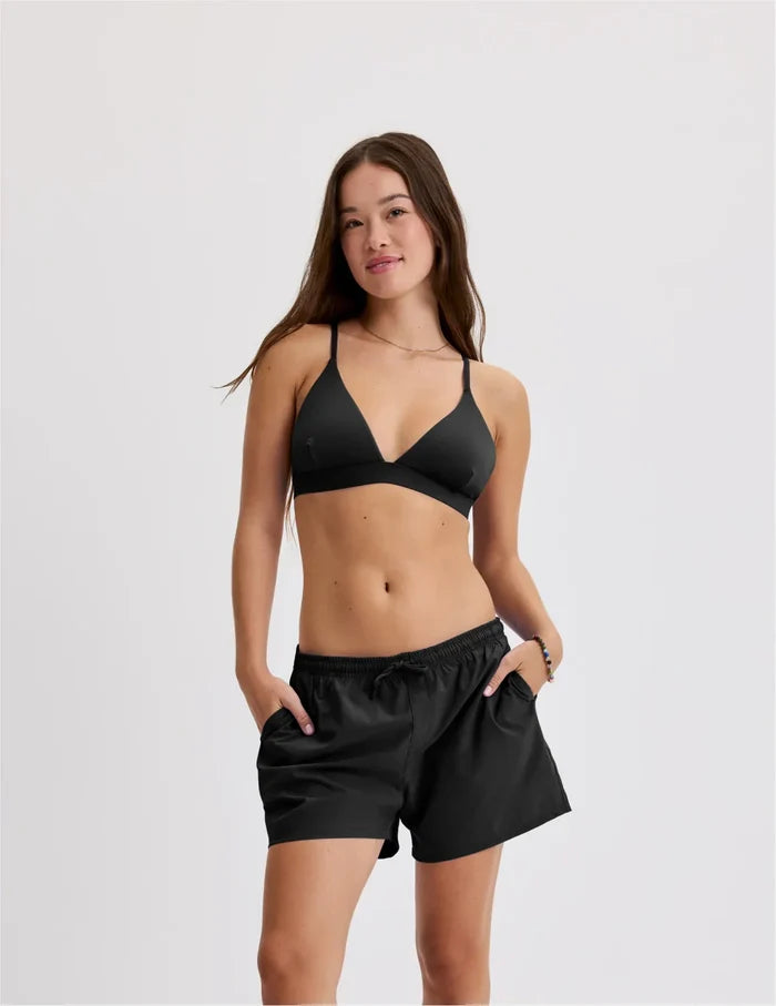 | Front view of model wearing the Teen Period Swim Board Shorts highlighting the coverage and fit | Black