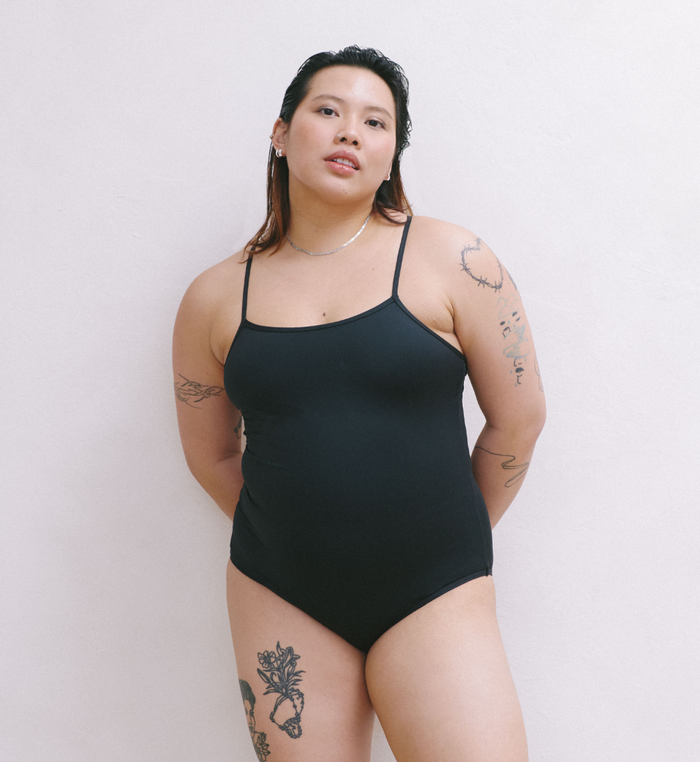 | Front view of model wearing the Teen Period Swim Freestyle One-Piece highlighting the coverage and fit | Black