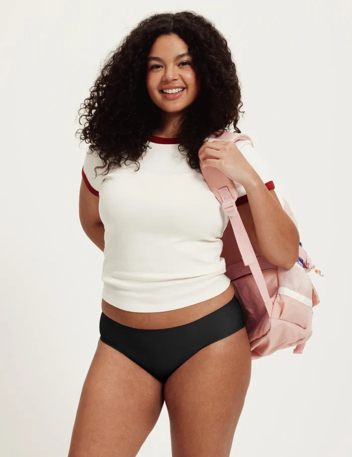 | Front view of model wearing the Teen SuperPlus Leakproof® No-Show Bikini highlighting the coverage and smooth fit | Black