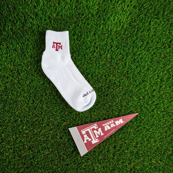 Flat lay of Del Campo Texas A&M Aggies golf socks with game-day props
