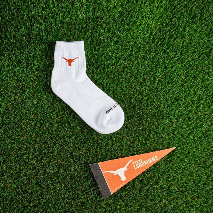 Flat lay of Del Campo Texas Longhorns golf socks with game-day props