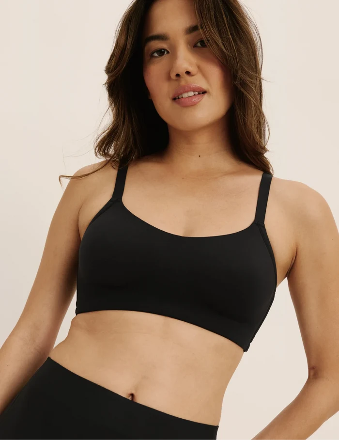 Julie is a 30C and wearing KNIX XS | Front view of model wearing the One&Only Scoop Bra®, highlighting the neckline, strap design, and  silhouette | Black
