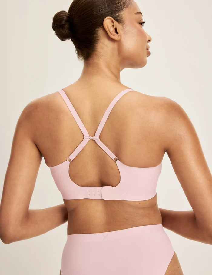 Ashley is a 32DD and wearing KNIX S+ | Back view of model wearing the Revolution Scoop Bra, highlighting the neckline, criss-cross strap design, and smooth silhouette | Rose Water