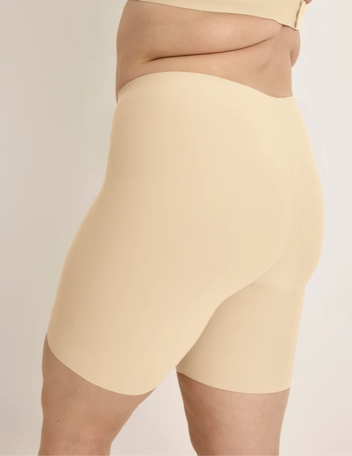 Beatrice is wearing KNIX XL | Side view of model wearing the Thigh Saver® 6” highlighting the coverage and smooth fit | Dune