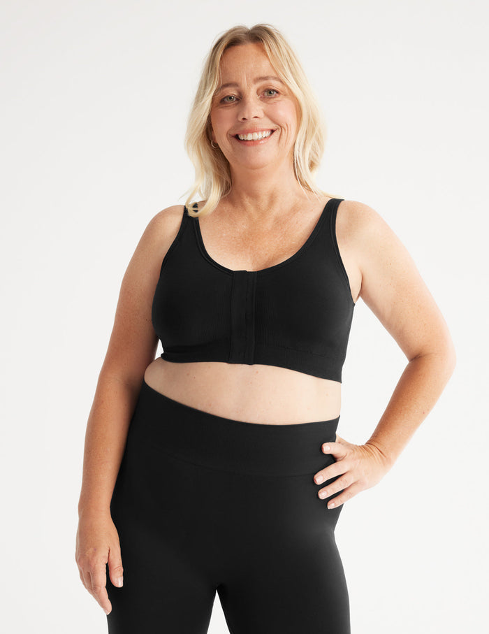 Kimberly is a customer and wears a Knix size L | Full-body view of model wearing the Ultra Soft Front Closure Bra, highlighting the neckline, easy front closure, and seamless knit silhouette| Black