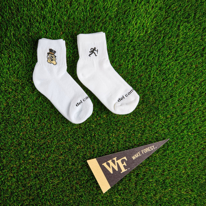 Flat lay of Del Campo Wake Forest Pack golf socks with game-day props
