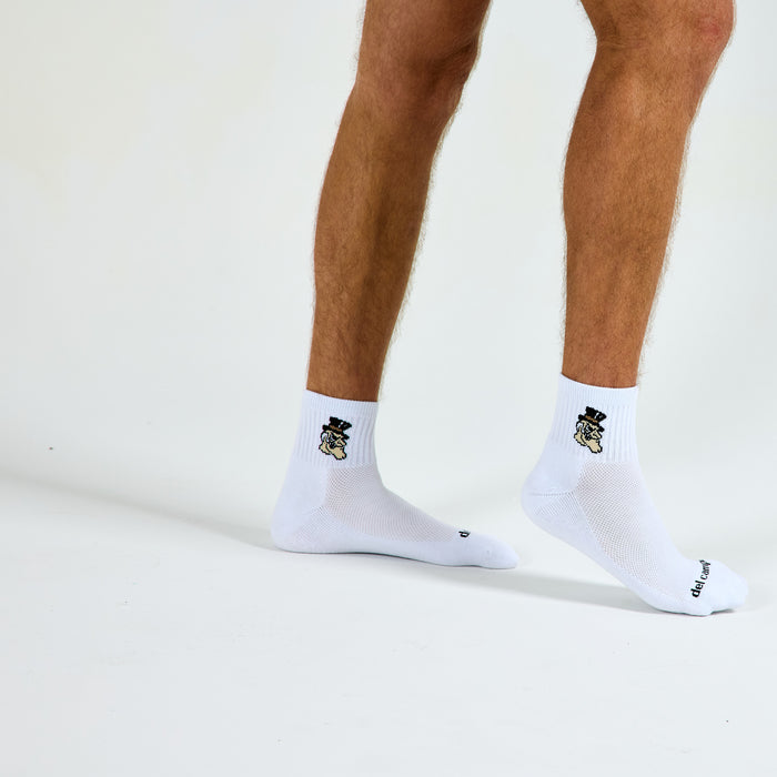 Man wearing Del Campo Wake Forest Demon Deacons golf socks, studio shot, no shoes