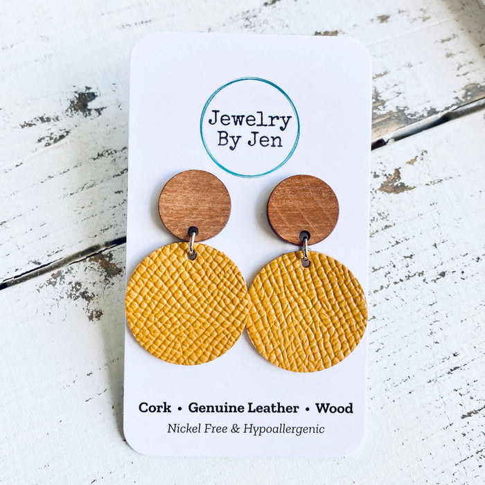 Measures 1.50 inches long. Wood stud earring with genuine leather circle attached. Stainless steel post. Nickel free and hypoallergenic. Due to display settings on your device, colors may appear different.